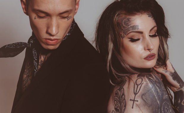 Couple with tattoos - back to back